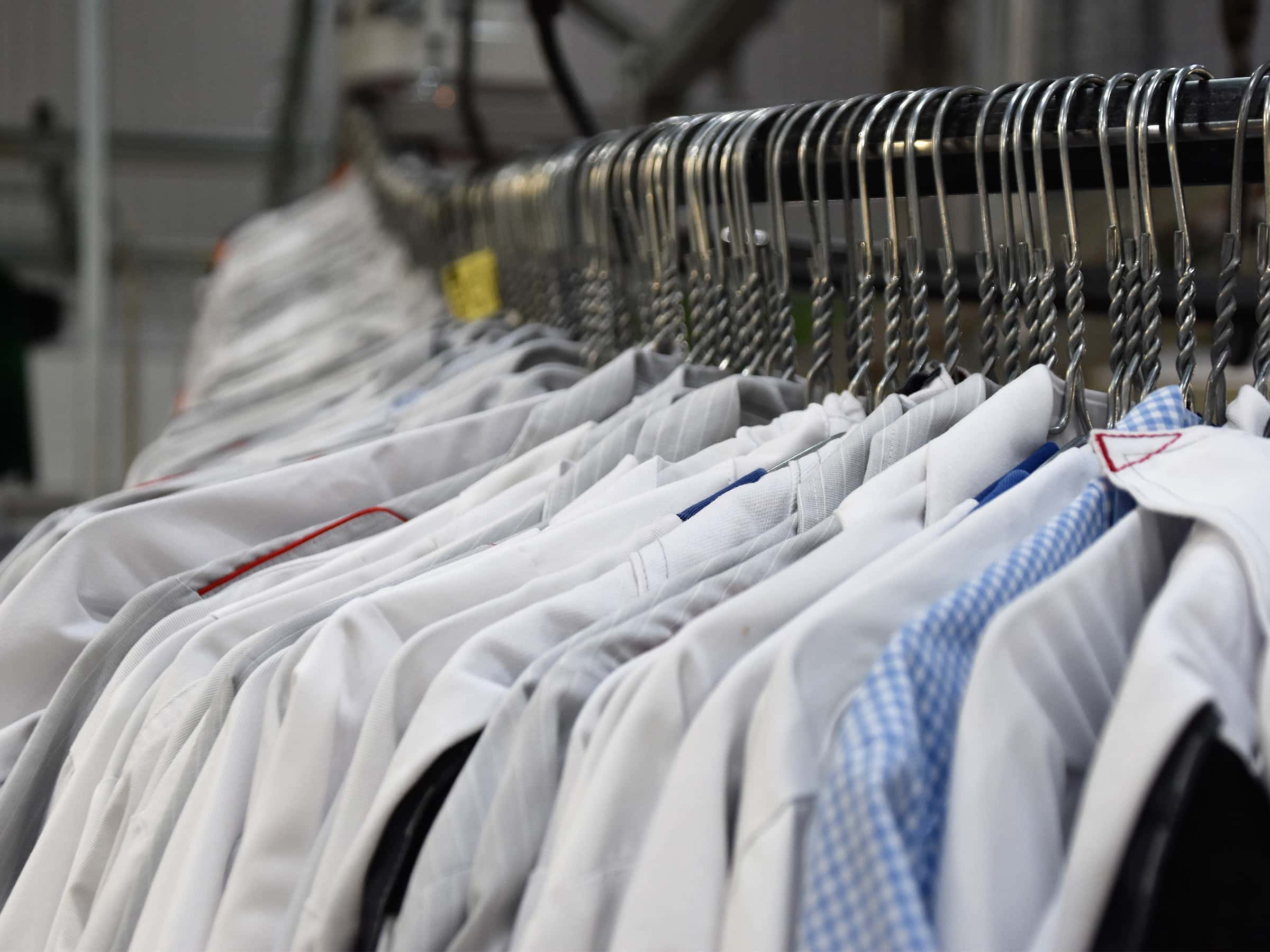 Verschiedene Hemden an einer Stange in einer Wäscherei