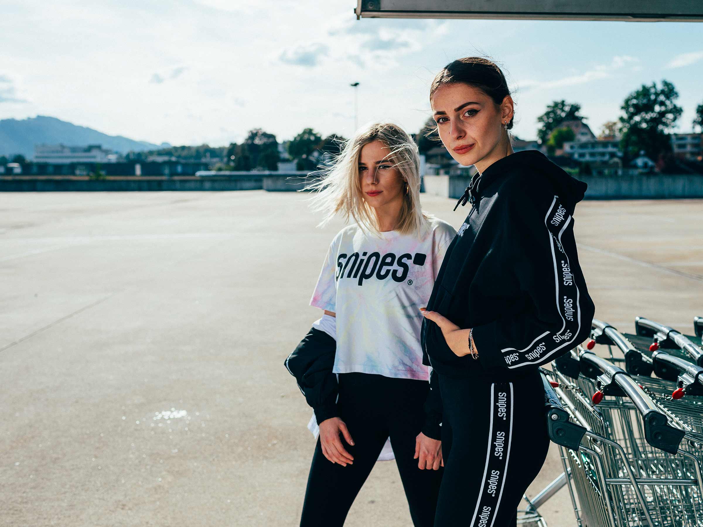 Zwei junge Frauen in einem Outfit von Snipes auf dem Parkdeck des Emmen Centers