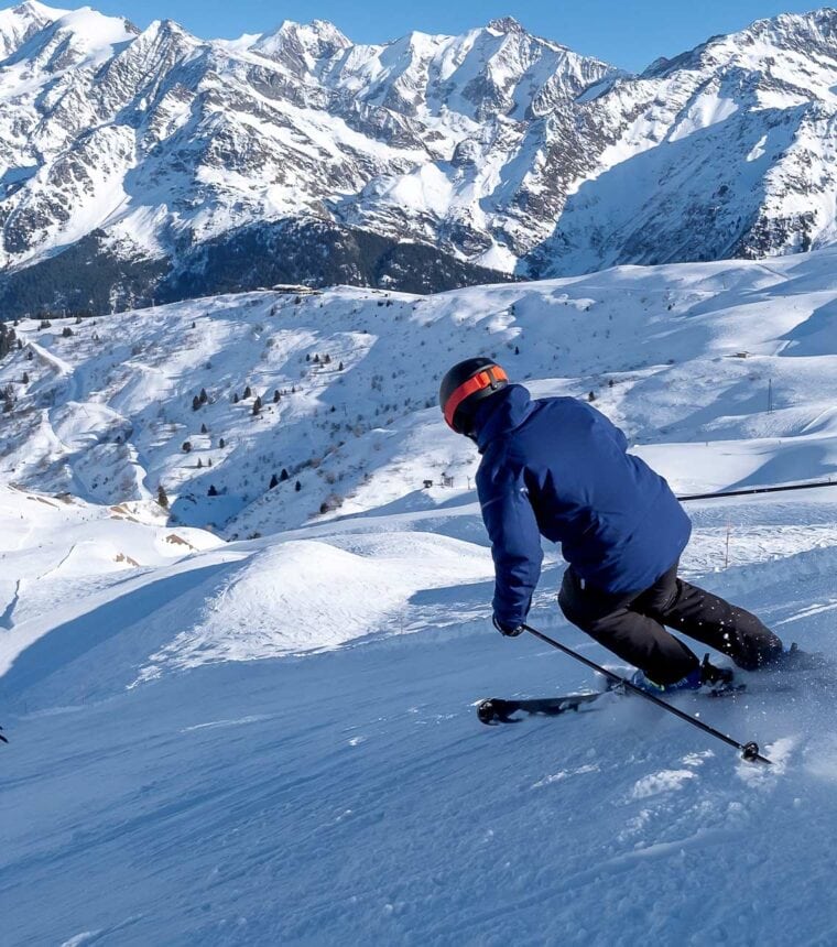 Eine Person fährt auf Skiern eine Piste runter